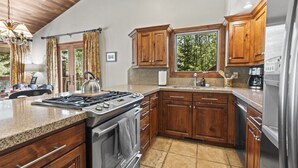 A modern kitchen with wooden cabinets, a gas stove, a built-in oven, and a stainless steel refrigerator. - Rare 3BR + Den 2-Min Walk to Park City Ski Base! (Park City)