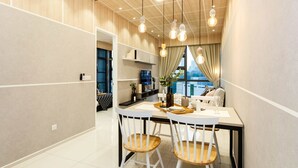 Un comedor moderno con una mesa blanca, dos sillas de madera e iluminación colgante.