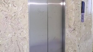 A metallic elevator door with a control panel on the wall beside it. - Trung Nhan Hotel (Cam Ly - Da Lat)