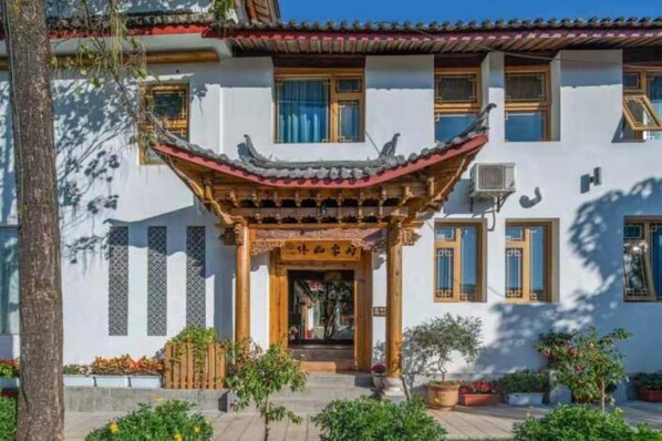 A traditional building with a distinct architectural style, featuring a prominent entrance with a decorative roof and wooden pillars.