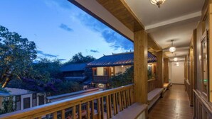 A wooden balcony with a view of traditional architecture and a clear sky. - Floral Hotel Lijiang Banshanyunfu (Lijiang)