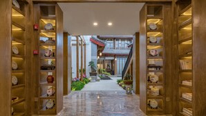 Un pasillo con estanterías de madera a ambos lados, que conduce a un edificio tradicional con tejado de tejas.