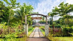 A pathway leading to a building with a sign reading "Kebun Sayur". - Mutiara Carita Cottages (Carita)