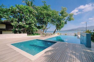 Una piscina al aire libre, sillones reclinables de piscina