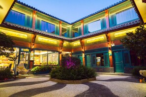 A traditional building with multiple levels, large windows, and a courtyard with plants and seating. - Floral Hotel Lijiang Nanzhao Mansion (Lijiang)