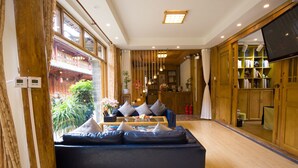 Un salon moderne avec un canapé, un plancher en bois et un téléviseur.
