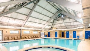 En inomhuspool med högt tak och ett antal omklädningsrum.