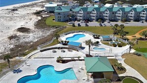 Ett semesterhotell med flera pooler, utsikt över stranden och ett stort byggnadskomplex.