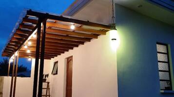 Une maison moderne dotée d’un patio couvert, agrémenté d’une pergola en bois et d’une table avec des chaises.