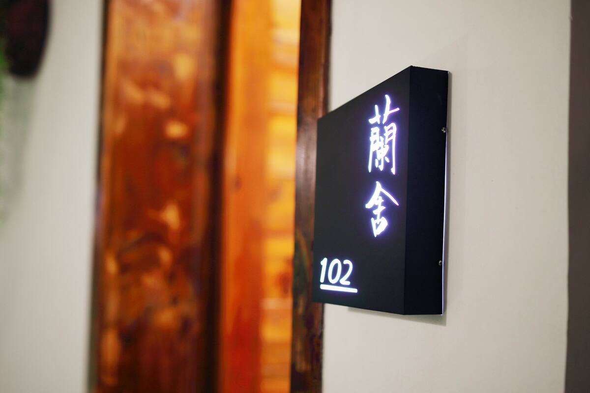 A hotel room sign with Chinese characters and the number 102.