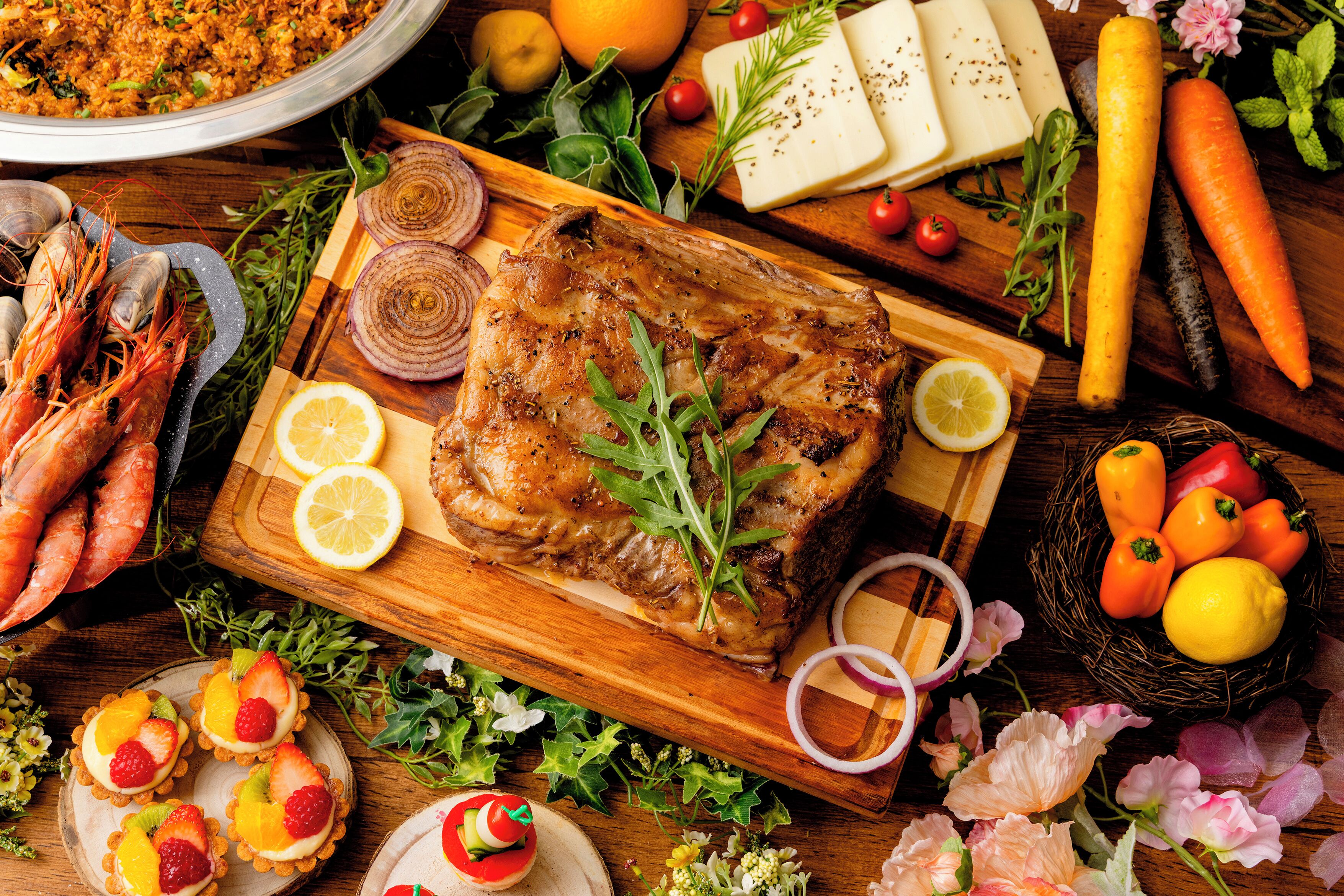 A wooden table with a roasted chicken, shrimp, and various vegetables.