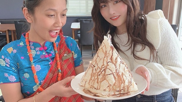 A person in traditional attire holding a plate with a dessert. - Paprika Hotel desu (Kisarazu)