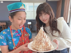 Une personne vêtue d’un costume traditionnel tenant une assiette de dessert.