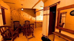 A rustic room with wooden furniture, a stone wall, and a wooden staircase.