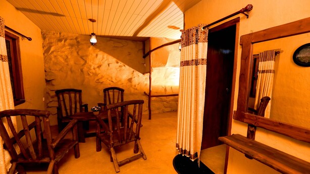 A rustic room with wooden furniture, a stone wall, and a wooden staircase. - Top Mountain Resort (Diyathalawa)