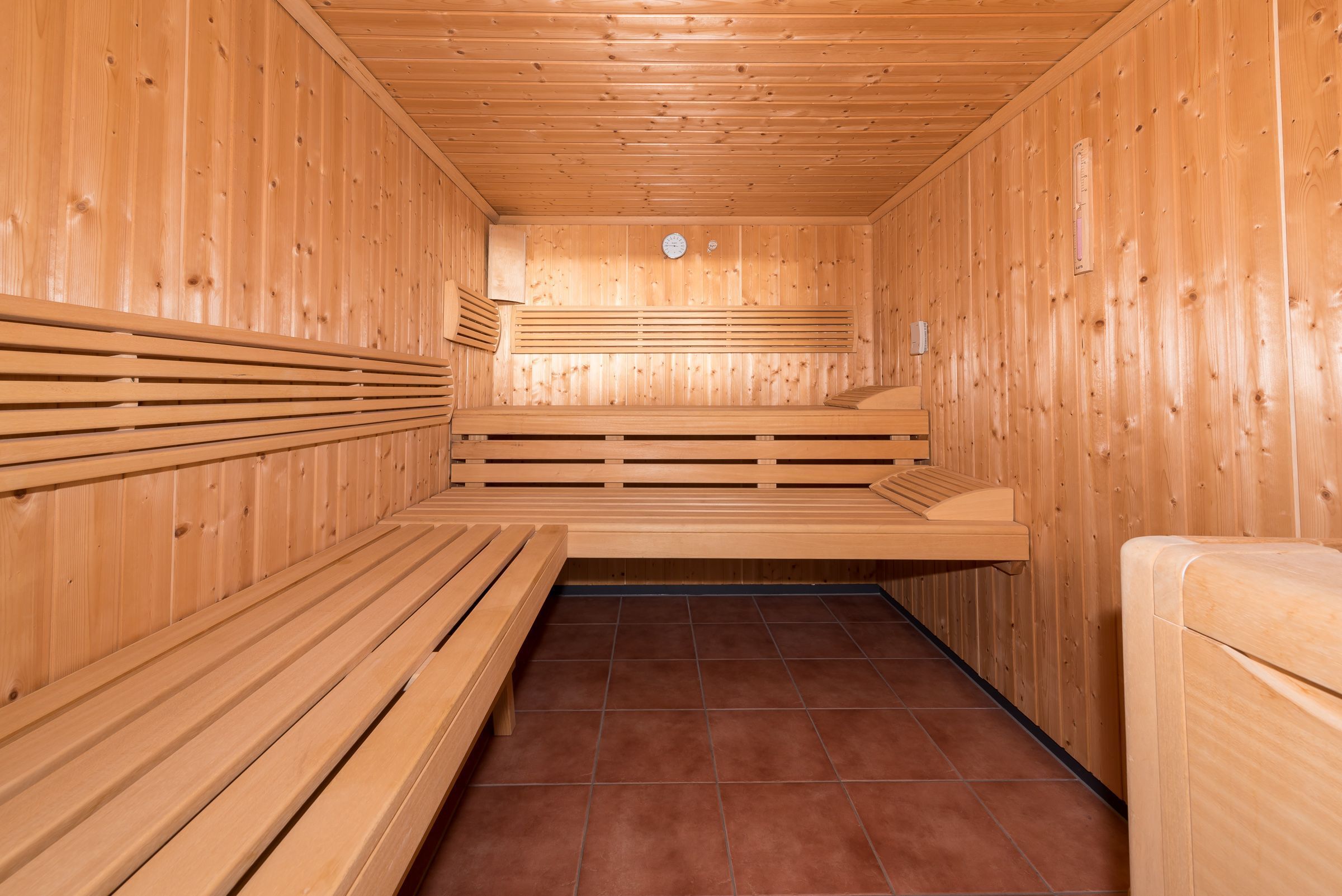 A sauna with wooden benches and a tiled floor.
