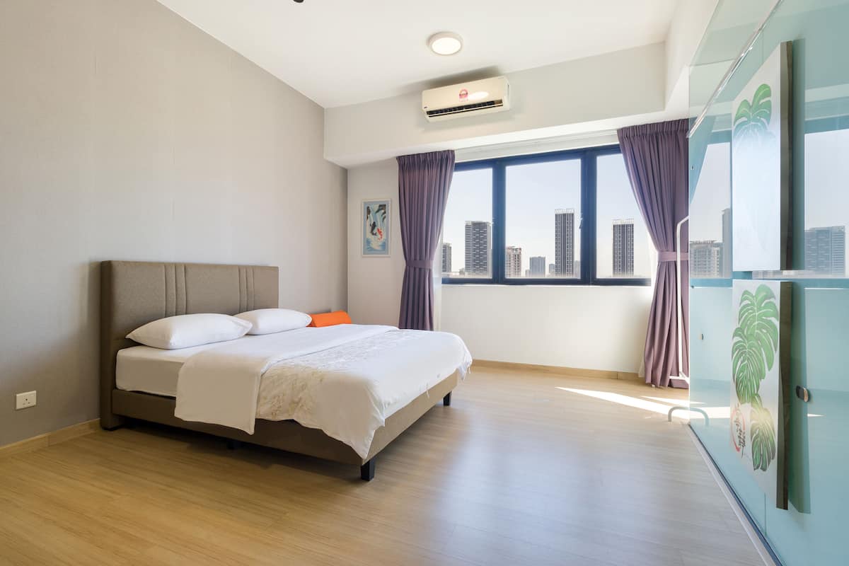 Une chambre moderne avec un grand lit, une vue sur la ville et un appareil de climatisation.