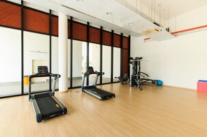 Una palestra con tapis roulant, cyclette e macchinari per pesi.