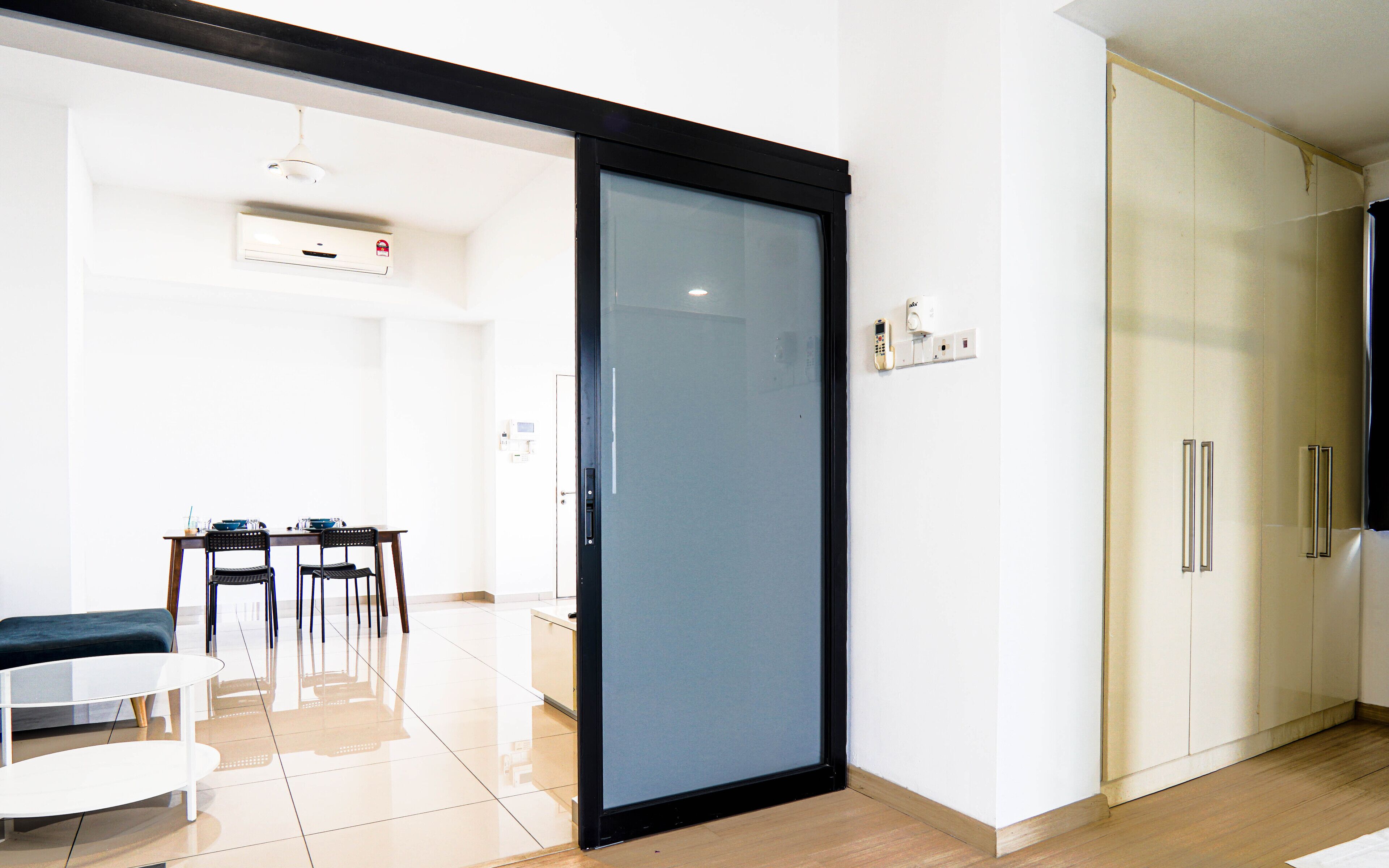 A modern kitchen with a sliding door, a dining area with a table and chairs, and a built-in oven.