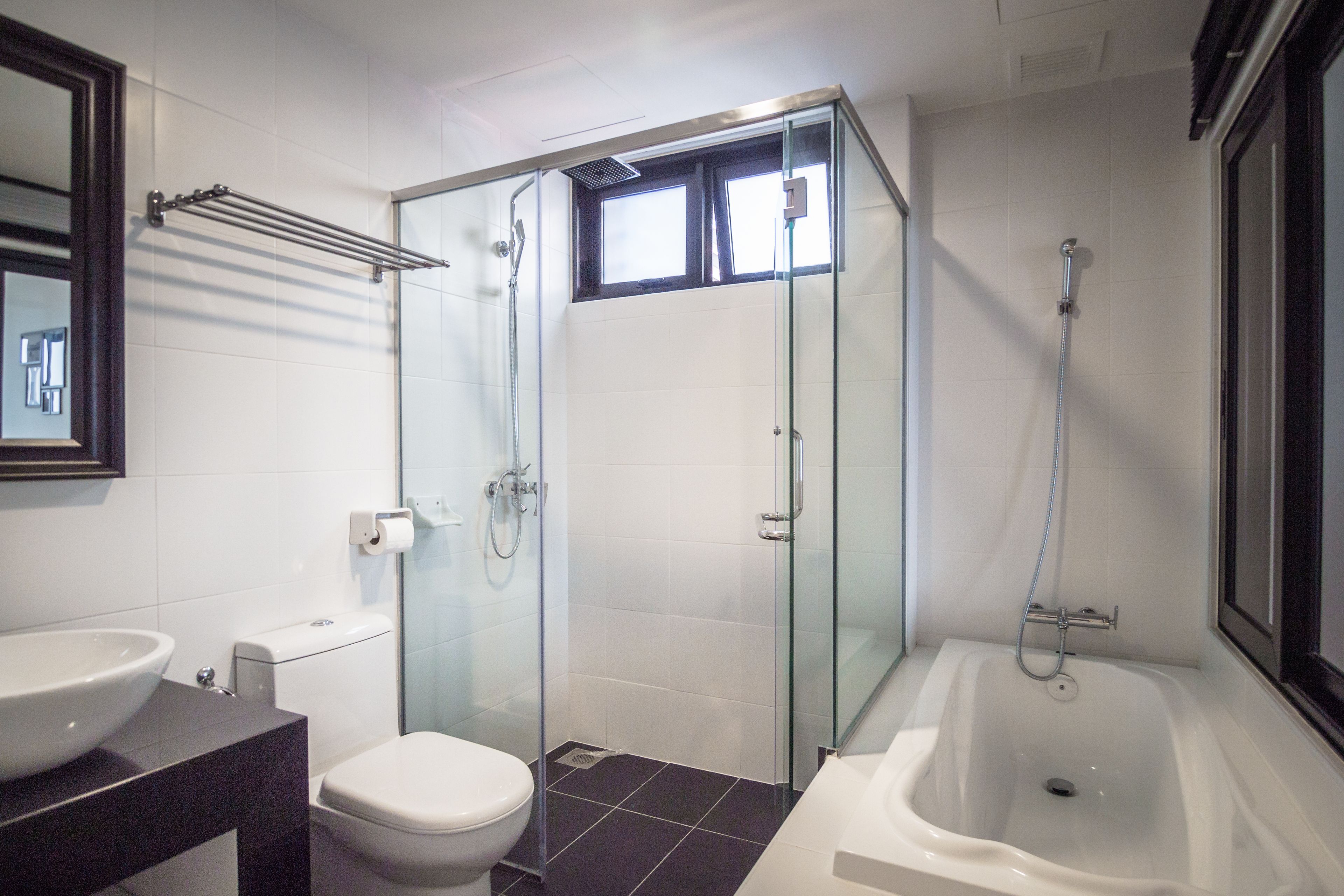 Un baño moderno con ducha acristalada, bañera y retrete.