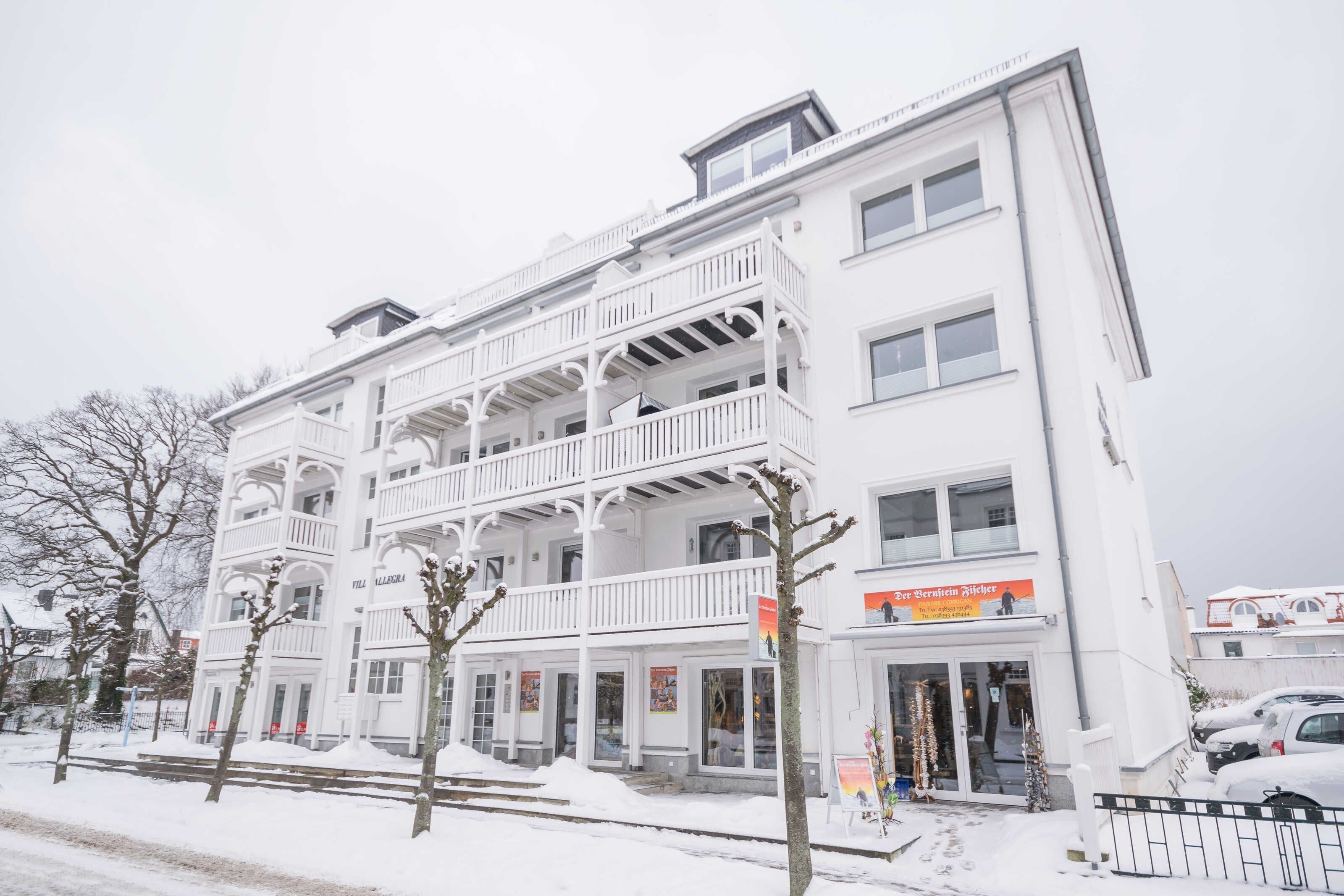 A multi-story building with balconies, a storefront, and a sign that reads 'Hotel.'
