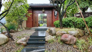 A traditional Japanese gate with a stone pathway leading through it.