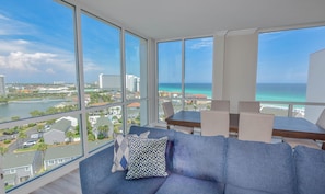 Ein modernes Wohnzimmer mit großem Balkon, einer Couch und einem Esstisch.