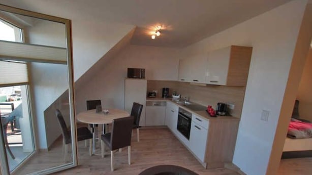 A compact kitchen with a dining area, a microwave, and a coffee machine. - Apartment 7 - Holiday apartments Jack & Richies (Greifswald)