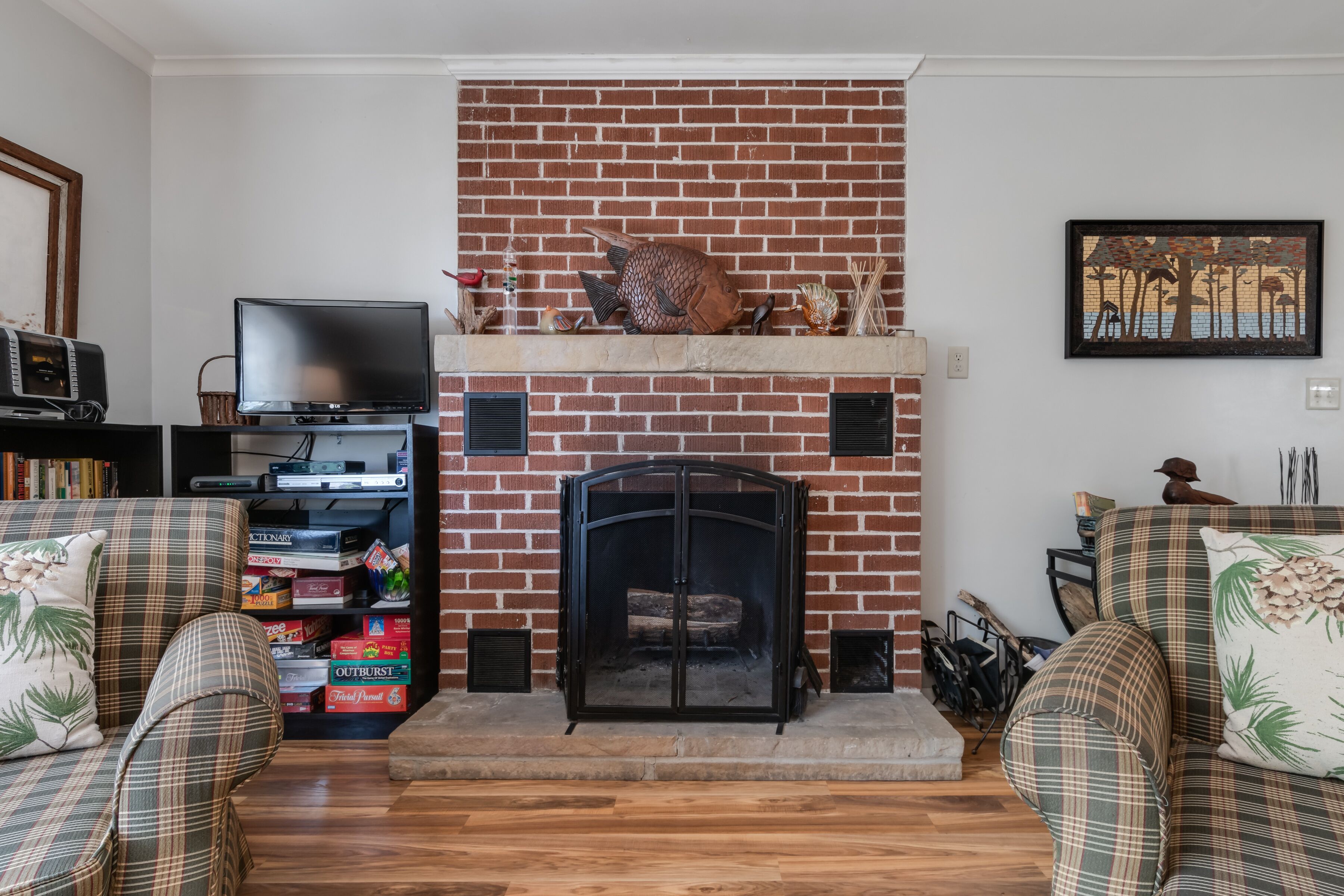 Ein Wohnzimmer mit Kamin, Fernseher und Bücherregal.