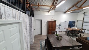A spacious kitchen with white appliances, a dining area with a wooden table and chairs, and a staircase leading to an upper level. - Included RV Spot + 10 min to Silverwood  (Hayden)