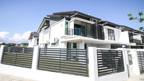 A modern two-story house with a white exterior, a black roof, and a gated entrance. - Alheri Austin Johor (Johor Bahru)