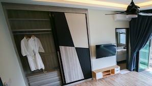 A modern bedroom with a walk-in closet, a flat-screen TV, and a ceiling fan. - Alheri Austin Johor (Johor Bahru)