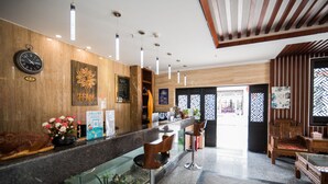 A modern hotel lobby with a reception desk, bar area, and seating. - Floral Hotel Dali Honglongjing Junrui (Dali)