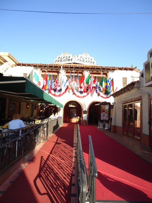 A plaza with a red carpet leading to a building with a sign reading "Plaza Theatre". - Palm Springs Condo in Lush Garden Setting. Central to Major Attractions. (Palm Springs)