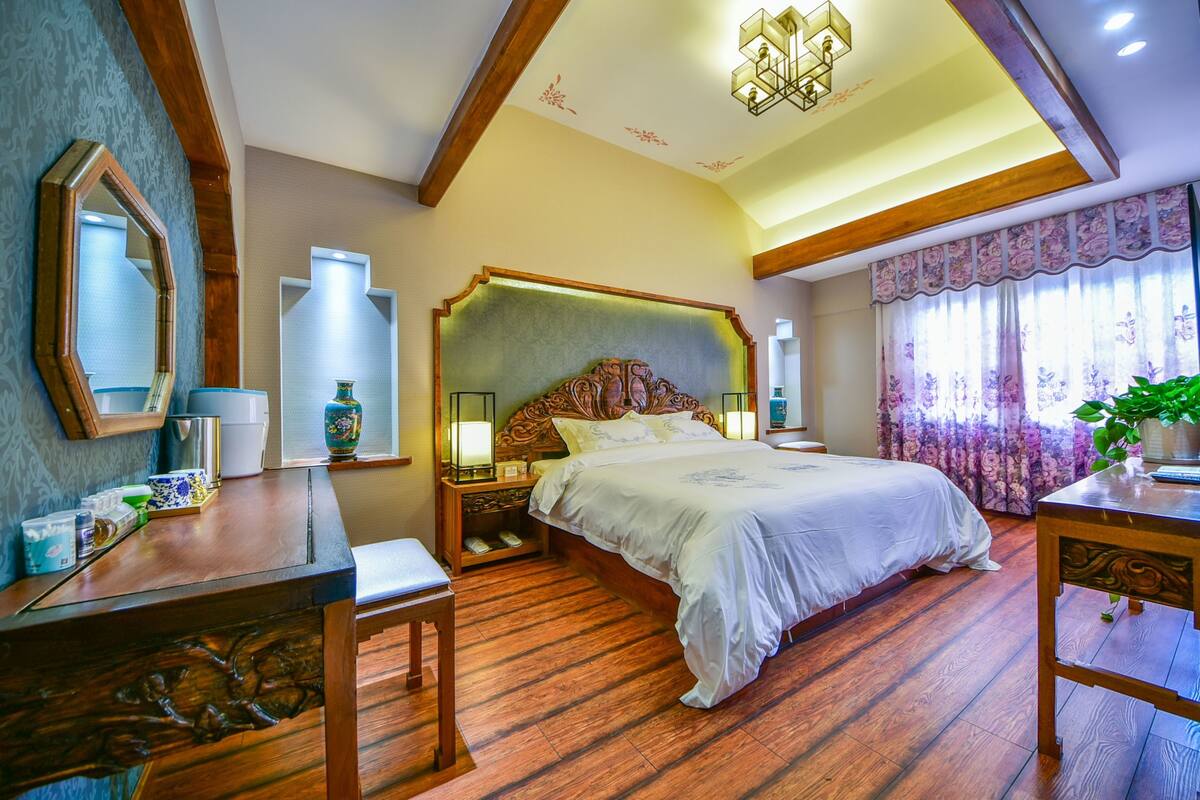Un dormitorio con una cama grande, muebles de madera y un candelabro.