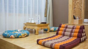 Una habitación con sofá, una mesita con botellas y un panel de madera decorativo.