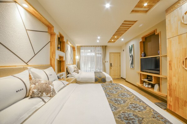 A hotel room with a large bed, a TV, wooden cabinets, and a patterned carpet.
