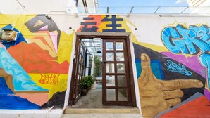 A colorful mural with a handprint and a mountain design on a building's exterior wall. - Floral Hotel Dali Yunsheng (Dali)