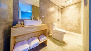 A modern bathroom with a wooden vanity, a large mirror, a toilet, and a shower area. - Floral Hotel Dali Yunsheng (Dali)