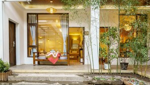 A traditional Japanese-style entrance with a wooden bench, a small garden with bamboo, and a water feature. - Floral Hotel Dali Yunsheng (Dali)