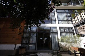 A building with a wooden facade, large windows, and a balcony.