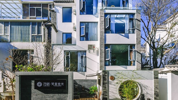 Ein modernes Hotel mit einer Steinfassade, mehreren Balkonen und einem Schild, das angibt, dass es sich um das Floral Hotel Time Collection handelt.
