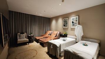 Relax in this stylish room with two single beds, a comfortable sofa, and a flat-screen TV.
