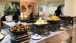 A buffet with various fruits and a marble counter. - Byland Star Hotel (Jinhua)