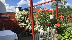 A garden with a red pergola, white flowers, and various potted plants. - ____To Bachrauschen____Wohlfuelwohnung in the picturesque Ulm valley, 5km to the Lahn valley (Greifenstein-Ulm)