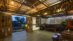 Een traditioneel Japans interieur met tatami vloeren, houten meubels en uitzicht op een tuin door open deuren.