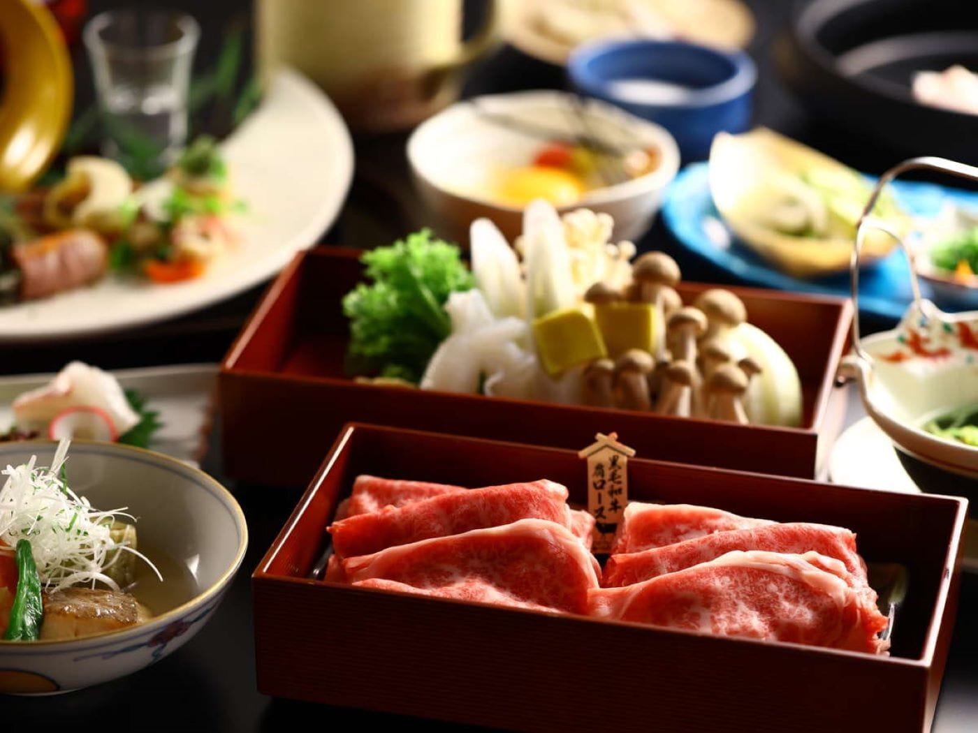 A traditional Japanese meal with various dishes including sashimi, vegetables, and tofu.