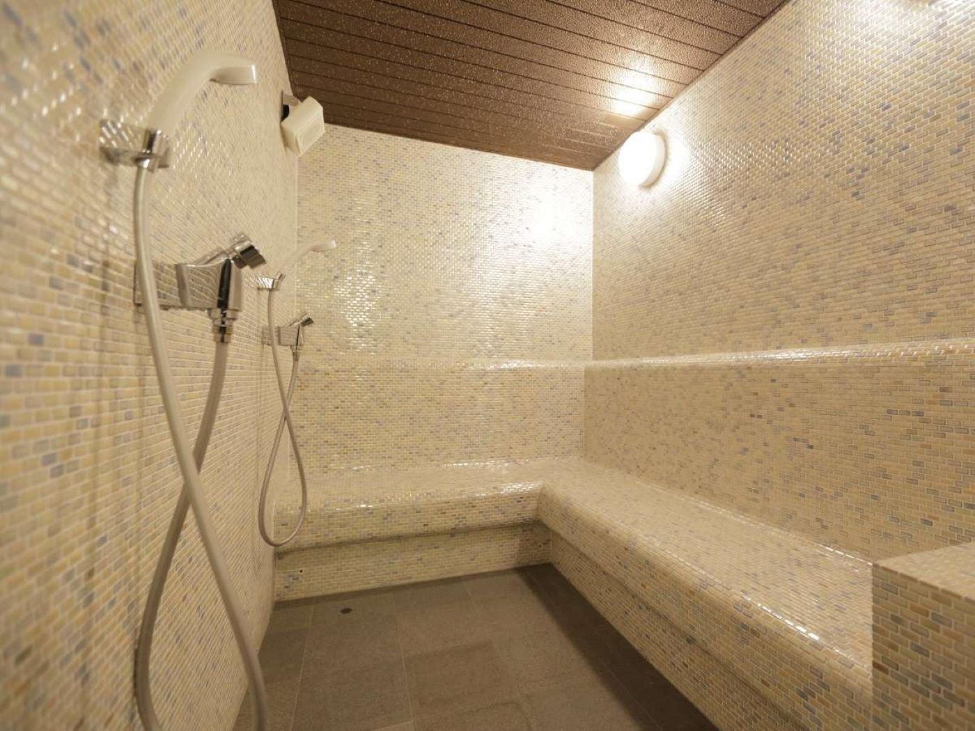 A small, enclosed shower area with tiled walls and a bench.