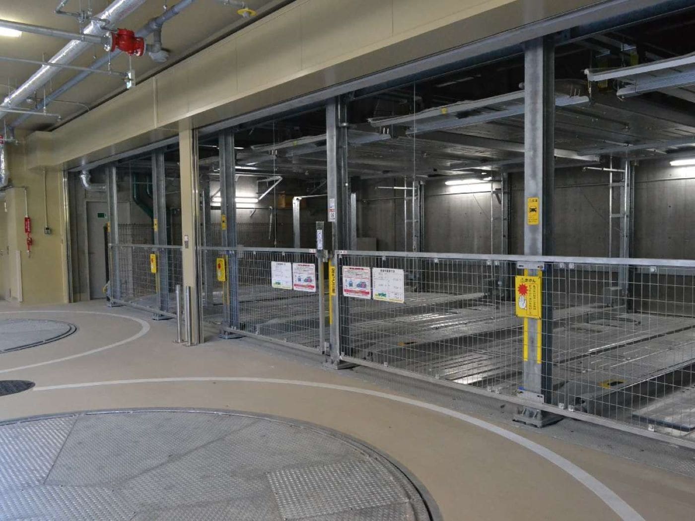 An empty parking garage with metal railings and concrete floors.