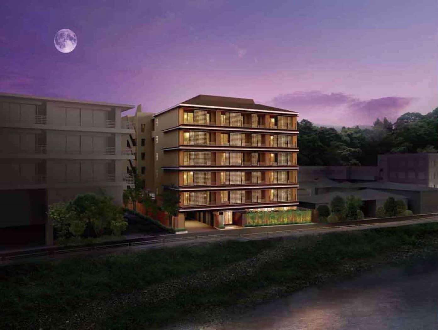 A multi-story hotel with a modern design, featuring balconies and a landscaped garden area.